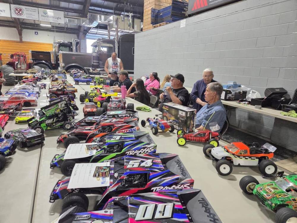 Rows of RC cars on tables at a club event